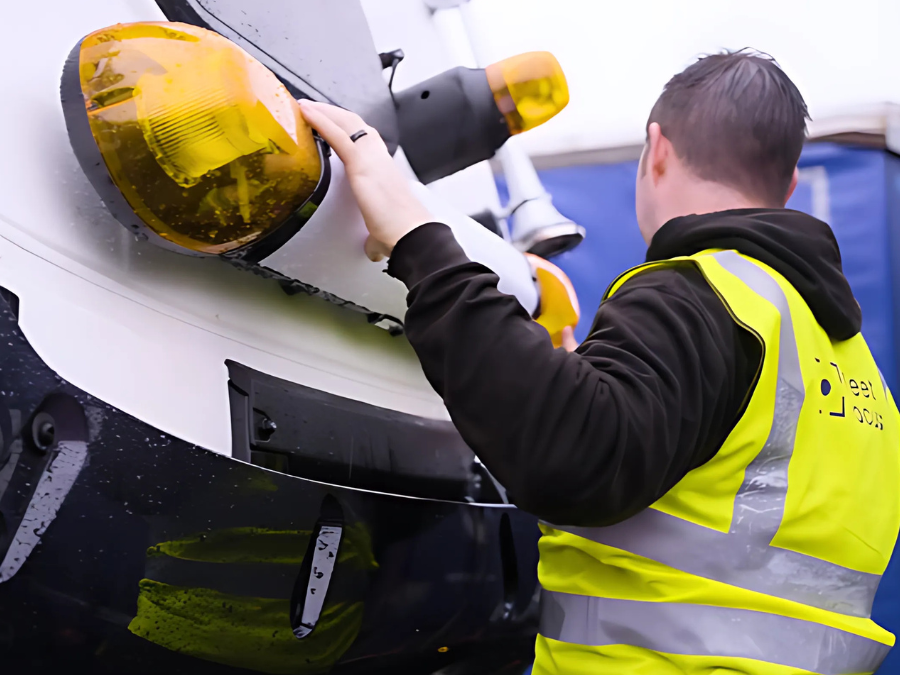 Fleet Focus engineer in high-visibility gear installing AI-powered fleet safety equipment on a lorry.