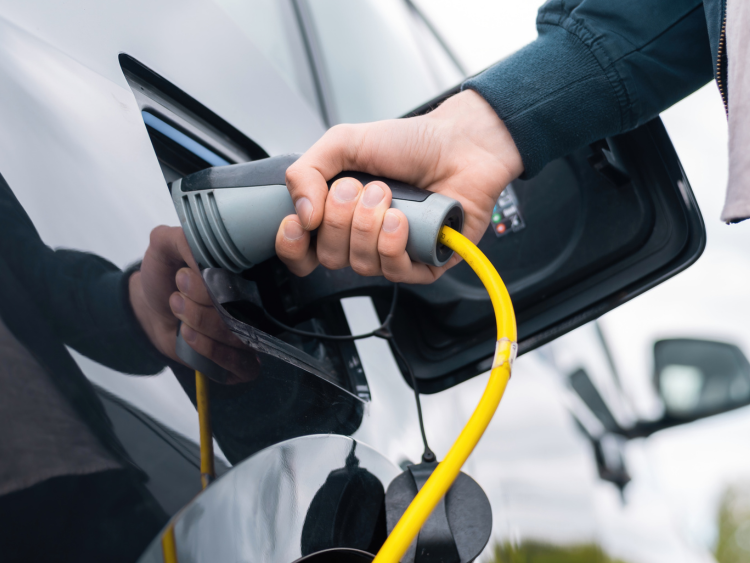 Fleet operator plugging an EV charger into a van, supported by Fleet Focus AI-powered technology.